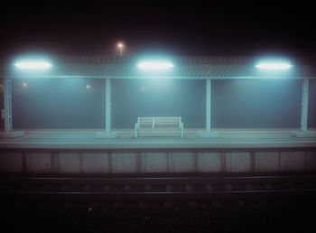 Illuminated railroad station platform at night