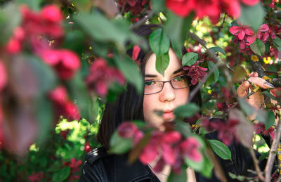 Portrait of young woman with red flowers