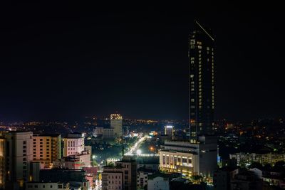 Illuminated buildings in city against sky at night