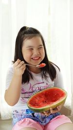 Smiling cute girl having watermelon at home