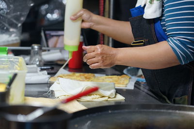 Midsection of man preparing food in kitchen