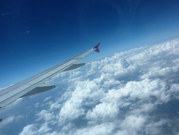 Cropped image of airplane against blue sky