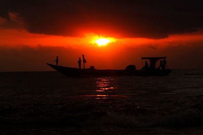 Silhouette of boat in sea during sunset