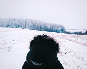 Close-up of man on snow field against clear sky