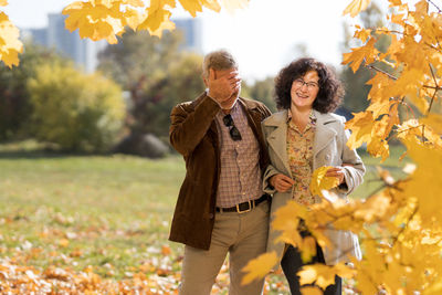 Portrait of smiling young woman standing in park