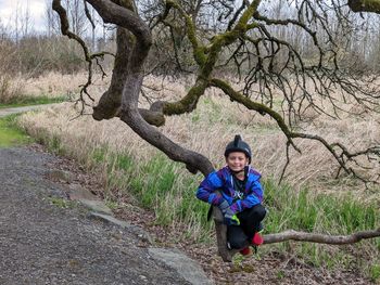 Low angle view of woman standing on tree