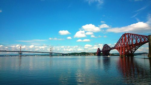 Bridge over river against cloudy sky