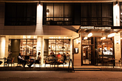 Chairs and tables in illuminated building at night