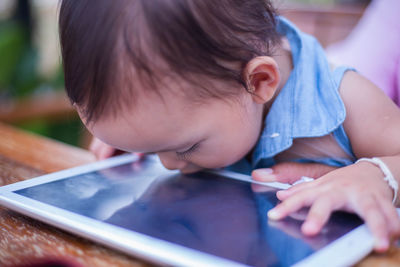 Close-up of girl kissing digital tablet