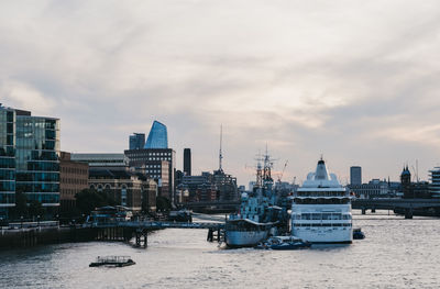Large holiday cruise ship moored on river thames by hm belfast during blue hour, london, uk.