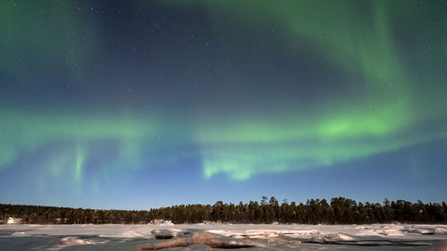 Scenic view of snow covered landscape against sky at night