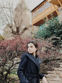 Portrait of woman against bare tree