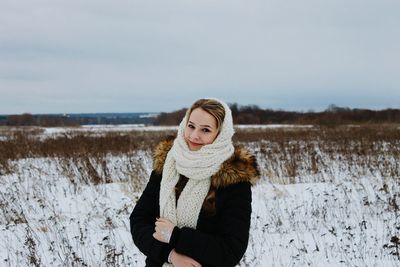 Portrait of woman standing on snow covered field