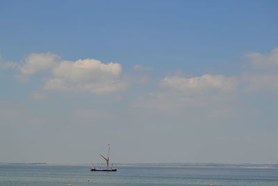 Sailboat in sea against sky