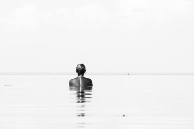 Man in swimming pool against sea