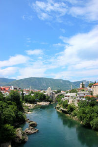 River amidst buildings in town against sky