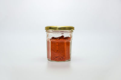 Close-up of glass of jar against white background