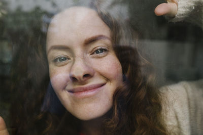 Smiling woman seen through glass