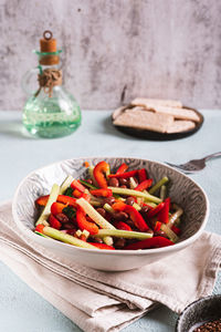 Vegetarian salad of red beans, cucumber and bell pepper in a bowl on the table vertical view