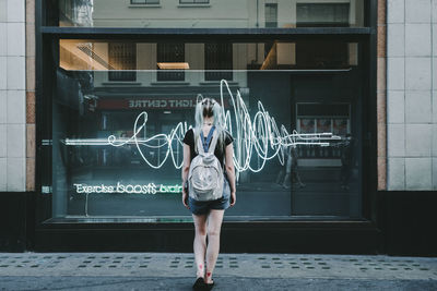 Full length of woman standing against building