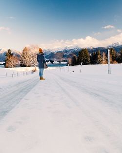 Full length of woman standing on snow covered landscape