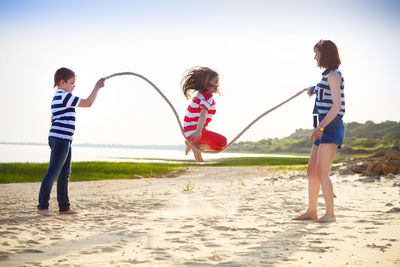 Boy playing with people against sky