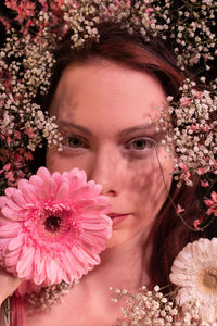 Portrait of woman with pink flower