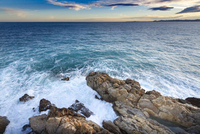 Scenic view of rocks in sea against sky