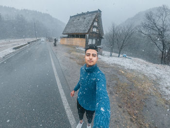 Portrait of smiling woman on road during winter