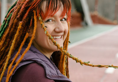 Portrait of young woman standing against blurred background