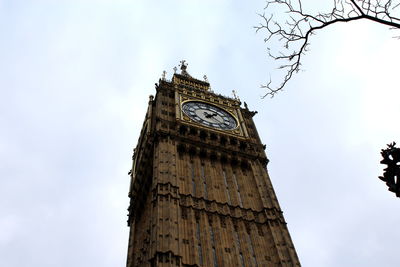 Low angle view of clock tower against cloudy sky