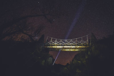 Low angle view of footbridge against sky during night