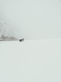 Snow covered landscape against clear sky
