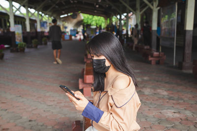 Midsection of woman standing on mobile phone