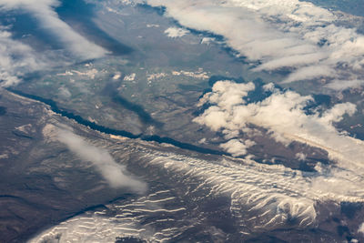 Aerial view of mountains against sky during winter