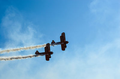 Low angle view of airplane against blue sky