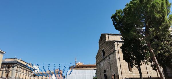 Low angle view of buildings against clear blue sky