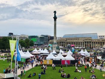 People at town square against cloudy sky