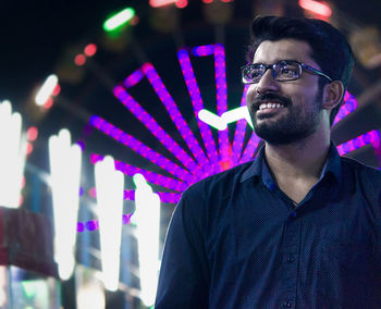 Portrait of happy man wearing eyeglasses at night