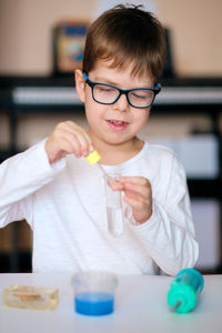 Boy is engaged in scientific research. a child with a test tube and a pipette in his hands. 