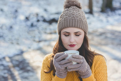 Close-up of woman with coffee cup in winter