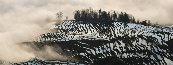 Scenic view of snow covered land against sky