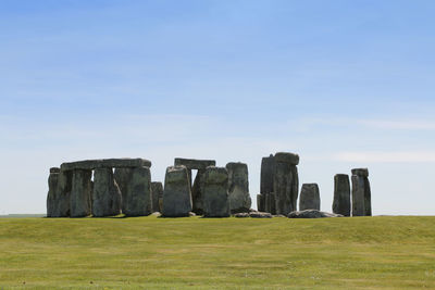 View of stonehenge with green meadow and blue sky on a sunny day in spring, united kingdom