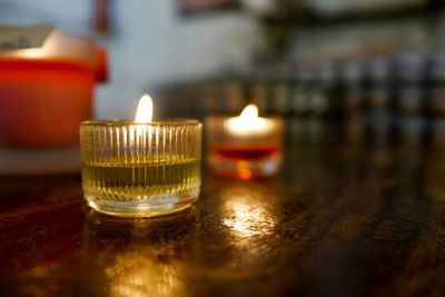 Close-up of lit tea light candles on table