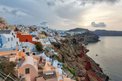 High angle view of townscape by sea against sky