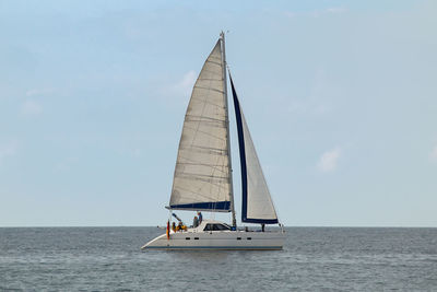 Sailboat in profile with some people on board and a germany flag on the side