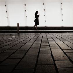 Side view of woman walking on footpath