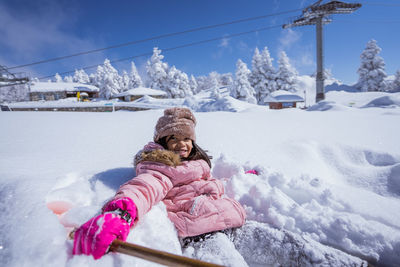 Full length of girl sitting on snow