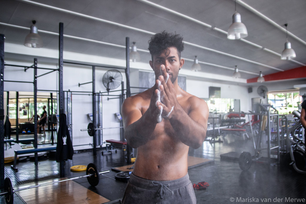 FULL LENGTH OF SHIRTLESS YOUNG MAN STANDING IN OFFICE