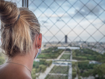 Rear view of woman looking through window